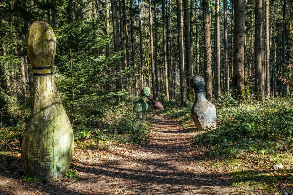 Giant bowling pins at different distances down a forest trail