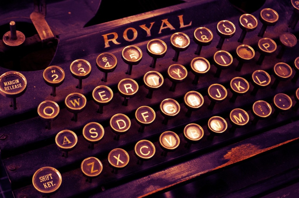An old fashioned typewriter dramatically illuminated with purple light